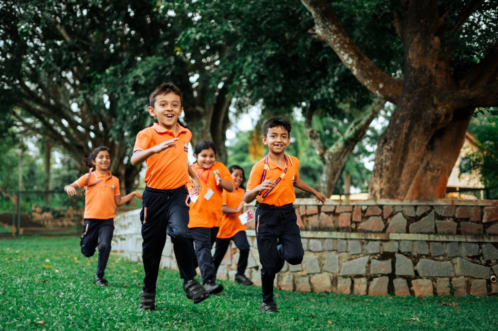 Kindergarten and Junior school children running happily on campus grounds